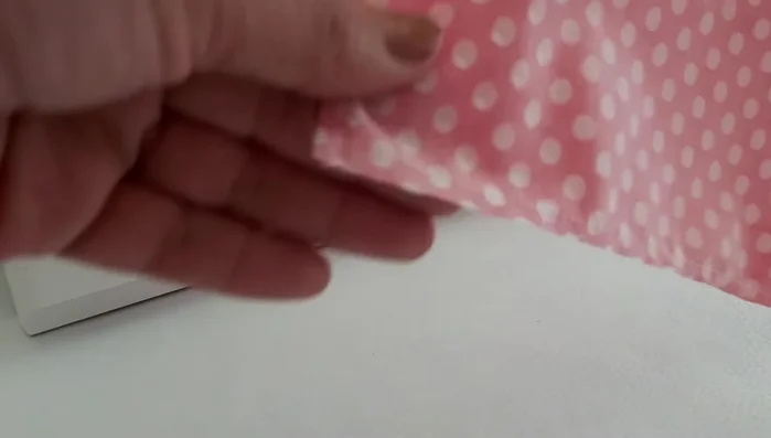 Voltear y cortar: Voltear la bandana por uno de los extremos. Planchar nuevamente. Cortar las puntas para formar un pico, teniendo cuidado de no cortar la costura.