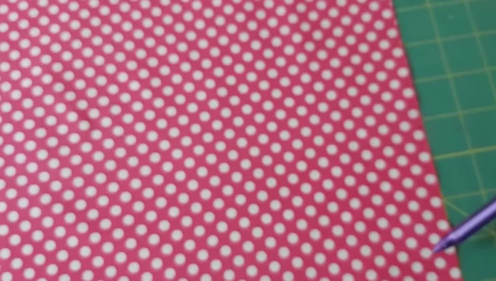 Marcar la tela: En cada esquina del cuadrado de tela (11x11 pulgadas), marcar 4 pulgadas desde cada borde. Unir las marcas opuestas con líneas.