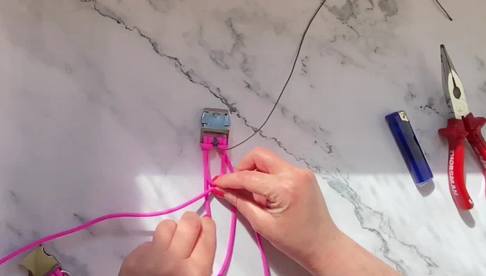 Comenzar a trenzar: Crear una cruz con dos hebras del cordón de inicio y colocar la hebra central (gris en el ejemplo) debajo.