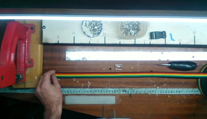 Hacer un doblez de aproximadamente 7 cm en un extremo de la cinta, cerca de la hebilla plástica.