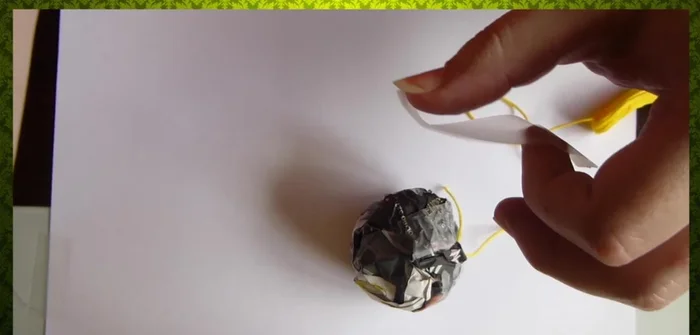 Repetir el proceso con diferentes colores de lana hasta cubrir completamente el papel.