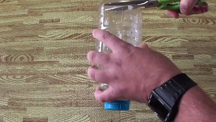 Preparar la botella: Corta la base de la botella de plástico. Haz cuatro cortes casi hasta la tapa, formando una cruz.