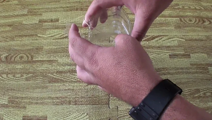 Colocar las ligas: Inserta una liga en dos cortes opuestos y otra liga en los dos cortes restantes, asegurándote de que lleguen hasta el fondo de la botella.