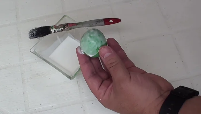 Crear la pelota: Si no tienes una pelota de plástico, infla un globo y cúbrelo con capas de pegamento diluido en agua y trozos de papel. Deja secar al aire o usa una secadora de pelo para acelerar el proceso.