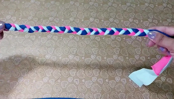 Cortar el excedente: Corta el exceso de tela de cada trenza para emparejar las puntas.