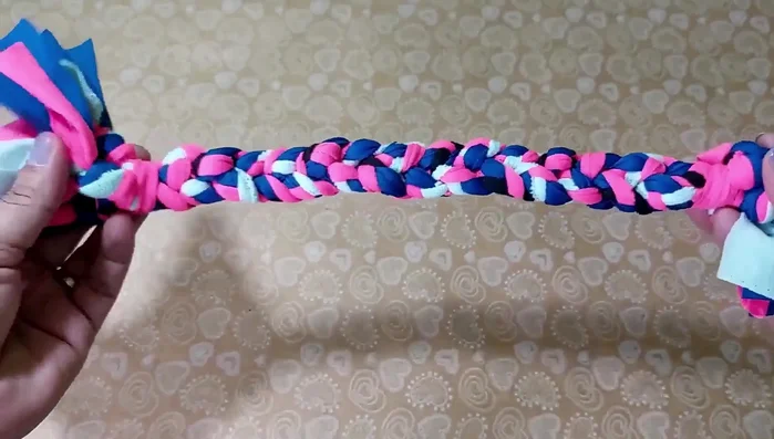 Nudo final y detalles: Al final de la trenza grande, asegúrala con otro nudo. Corta los extremos en pequeñas tiras para crear flecos.