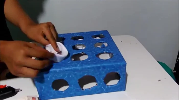 Añade detalles decorativos con tela en los bordes de la caja, pegándola por dentro o por fuera.