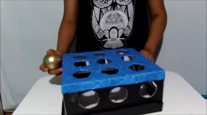 Coloca una pelota dentro de la caja para formar la cabeza de la mascota. Puedes usar diferentes materiales para la cabeza.