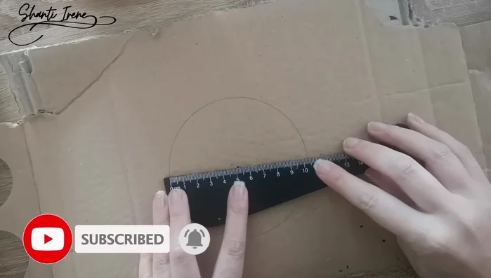 Forrar la base de cartón con tela: Cubrir el círculo de cartón con tela (fieltro) o lana tejida.