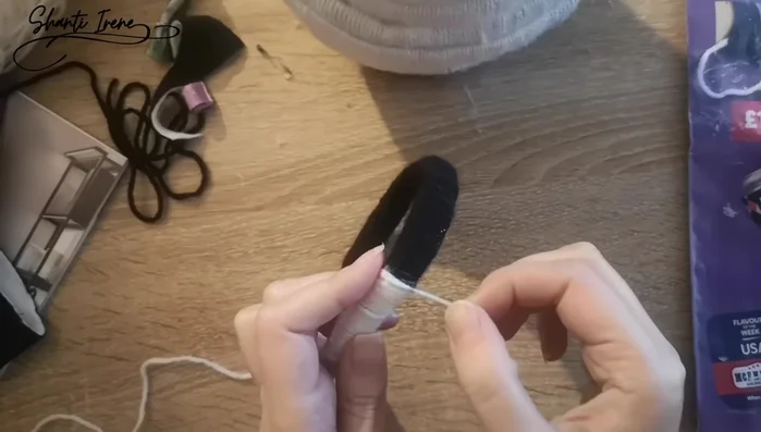 Construir la cabeza: Realizar canutos de papel forrados con lana para la cabeza, disminuyendo progresivamente el tamaño. Ajustar la distribución de los colores (blanco y negro) para lograr el efecto deseado.