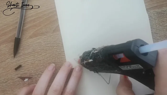 Crear la nariz: Recortar un triángulo de cartón, forrarlo con lana rosa, y pegarlo en la cara.