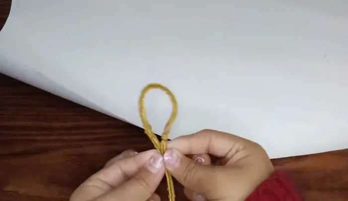 Unir las dos medidas de mecate en la cartulina y marcar la mitad de cada una.