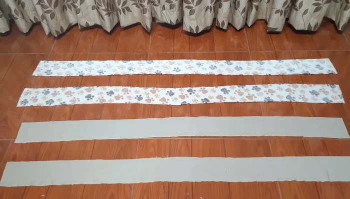 Cortar tiras largas de 10 cm de ancho para el contorno de la cama (dos tiras de cada color de tela peluche).