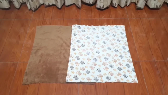 Cortar tiras largas de 10 cm de ancho para el contorno de la cama (dos tiras de cada color de tela peluche).