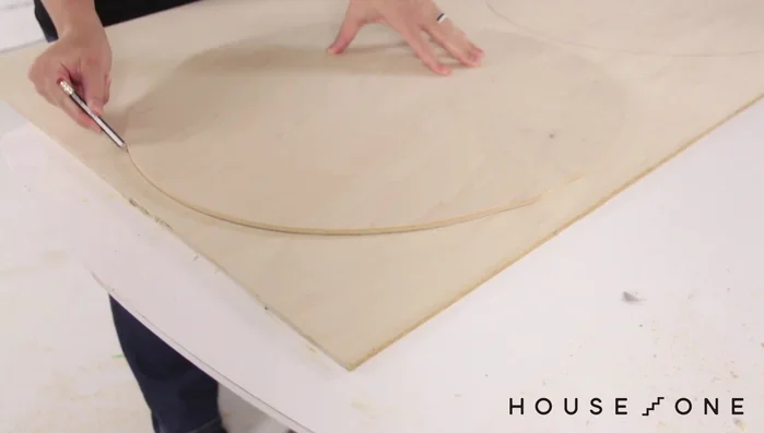 Crea un segundo óvalo más pequeño para la entrada al nivel inferior. Usa el taladro y la broca de paleta para iniciar el corte y luego termina con la sierra de calar.