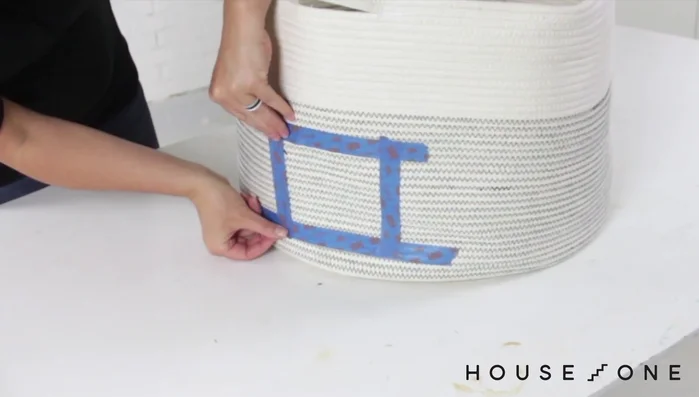 Crea una entrada adicional al nivel inferior en la cesta tejida. Separa las fibras de la cesta cuidadosamente y corta una ranura para crear la abertura sin deshacer la cesta. Aplica pegamento y una puntada para asegurar las solapas.