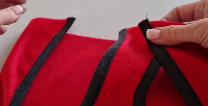 Unir el cuello: Doblar una tira de tela por la mitad y coserla formando un círculo. Unir esta tira al cuello del abrigo, haciendo coincidir los cuartos.