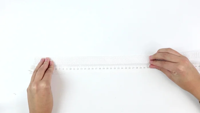 Cortar la cinta: longitud del cuello + 12 cm. Introducir la anilla.