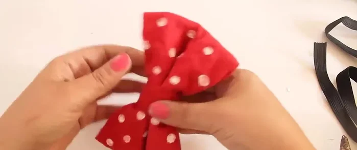 Envuelve el moño con la tira y pega la otra orilla por detrás con silicón.