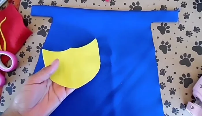 Cortar dos trozos de velcro de 2 pulgadas y colocarlos en los lados de la capa para sujetarla.