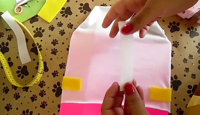 Cortar dos círculos para las patas del gato. Pegar velcro en la parte trasera de la playera y en la capa para unirlas.