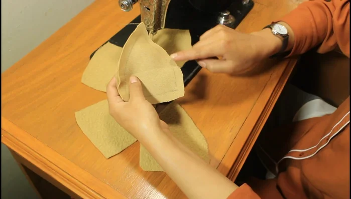 Dale forma a la boina: Marca la mitad y 1 cm hacia abajo, haz una curva para darle figura. Coloca un botón en el centro.