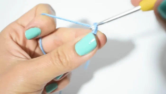 Resorte del cuello: Hacer 12 cadenas (ajustar según medida del cuello), subir con 1 cadena (cuenta como punto bajo), hacer puntos bajos en cada cadena (12 puntos bajos en total).