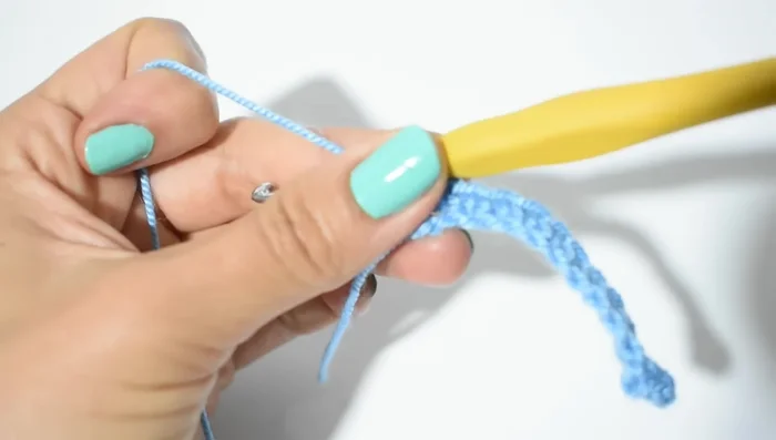 Vueltas del cuello: Repetir hasta la medida del cuello. Subir con 1 cadena, hacer punto elástico (punto bajo tomando solo la hebra trasera) en cada punto. (Para un cuello de 30 cm, se necesitan 52 vueltas)