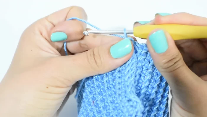 Vuelta de puntos bajos alrededor del cuello: Subir con 1 cadena, hacer un punto bajo por cada punto del resorte (52 puntos bajos). Cerrar con un punto deslizado.