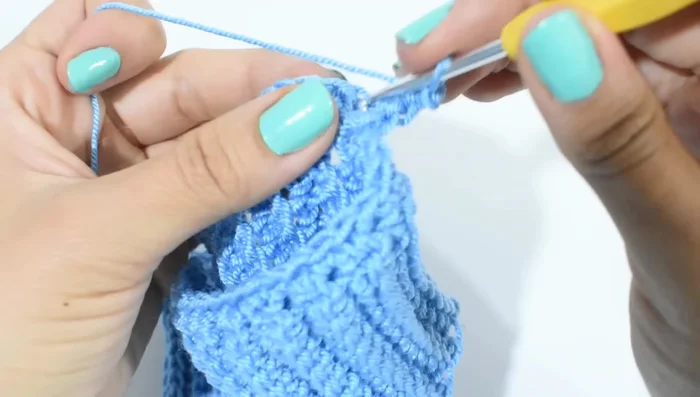 Vueltas siguientes: Subir con 2 cadenas, tejer en el centro de cada V (punto alto, cadena, punto alto). Repetir hasta completar el largo deseado (restar 10 cm al largo total del perro).