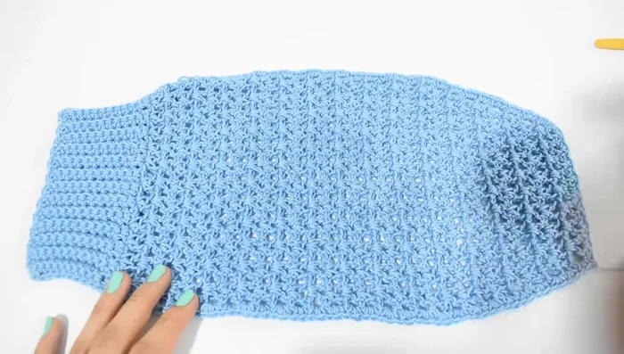 Parte del pecho: Unir el hilo a la vuelta anterior a las disminuciones. Tejer 24 puntos bajos (ajustar según el pecho del perro). Repetir el punto elástico hasta donde se quieran los ojales.