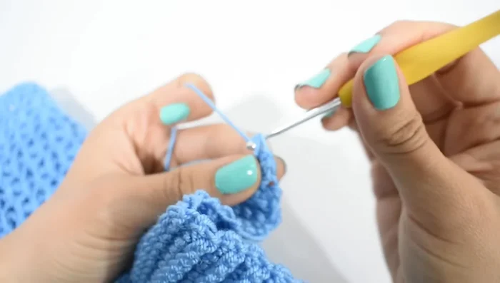 Ojales: Hacer ojales con 3 cadenas, saltando 3 puntos, y tejer 10 puntos bajos. Repetir.