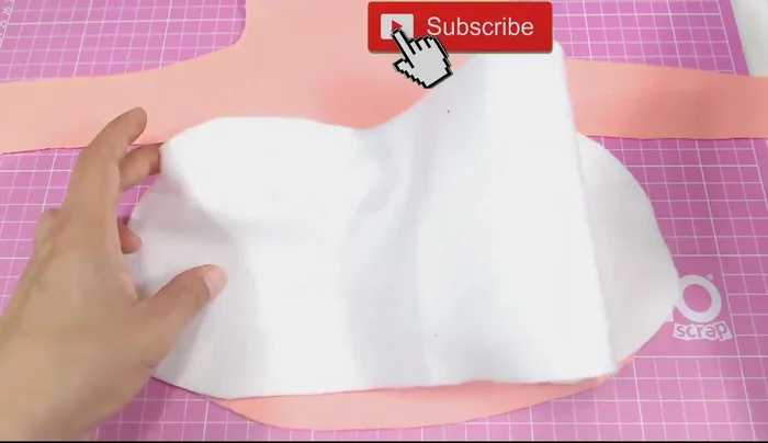 Pegar el rectángulo blanco a la pieza principal del vestido con silicona caliente, creando pequeños pliegues para un efecto fruncido.