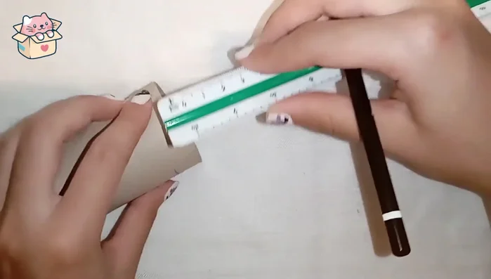 Marcar y cortar el cartón: Con la regla, marcar el cartón de papel higiénico a 1.5 cm de ancho alrededor. Recortar con cúter y tijeras.