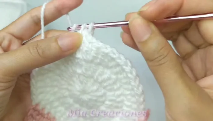 Tejer la carita: Tejer puntos bajos alrededor, haciendo aumentos en las esquinas de las orejas.