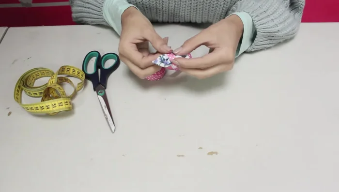 Añadir la pinza o elástico: Pegar una pinza para el pelo o un elástico con silicona caliente a la parte trasera del moño.