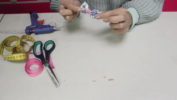 Añadir la pinza o elástico: Pegar una pinza para el pelo o un elástico con silicona caliente a la parte trasera del moño.