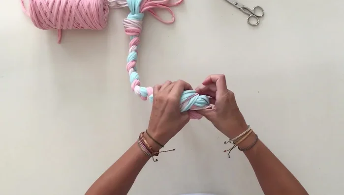 Dobla las tiras por la mitad y forma una cruz. Coloca la pelota en el centro.