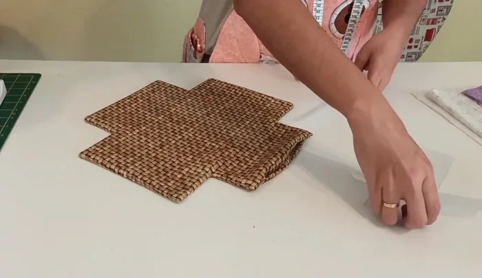 Insertar el cuadrado de plástico en la base, asegurándose de que quede bien pegado a las costuras. Coser para cerrar la abertura.