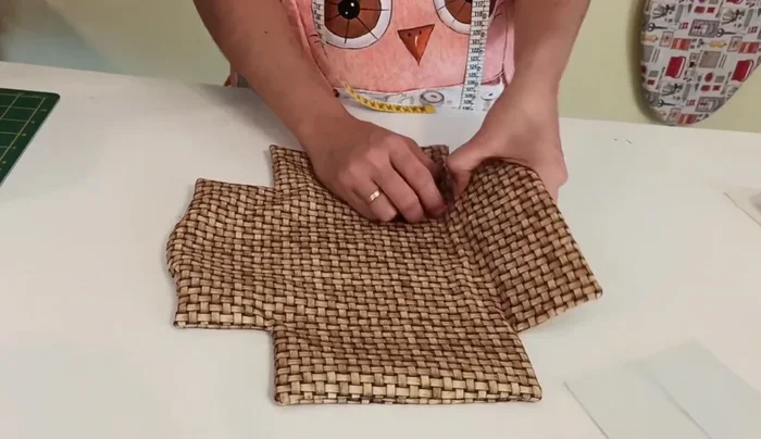 Insertar el cuadrado de plástico en la base, asegurándose de que quede bien pegado a las costuras. Coser para cerrar la abertura.