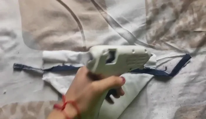 Doblar y pegar asegurando el listón/cordón.