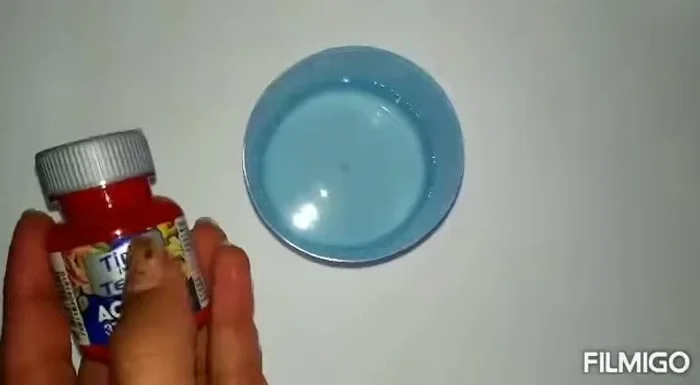 Aplicar la pintura: Utilizando una botella con sistema de aspersión, rociar la mezcla de pintura sobre la tela enrollada.