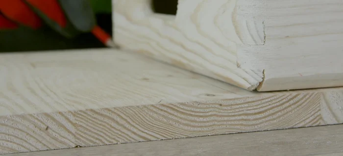 Marcar y cortar el agujero para el tubo en la tabla intermedia. Usar la tabla base como plantilla para marcar el círculo y el agujero en la tabla intermedia.