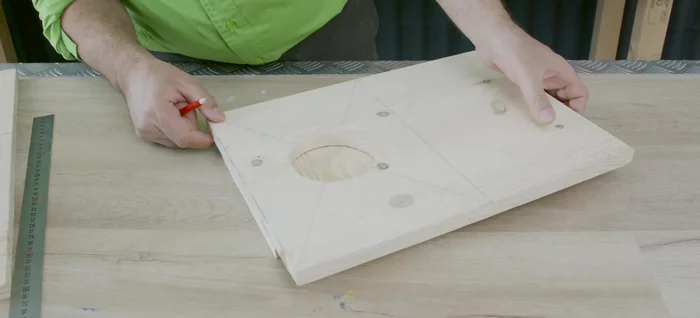 Crear el hueco para la caja en la tabla superior. Marcar y cortar un círculo de 20 cm de diámetro en uno de los laterales de la caja de madera.