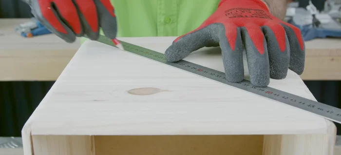 Crear el hueco para la caja en la tabla superior. Marcar y cortar un círculo de 20 cm de diámetro en uno de los laterales de la caja de madera.