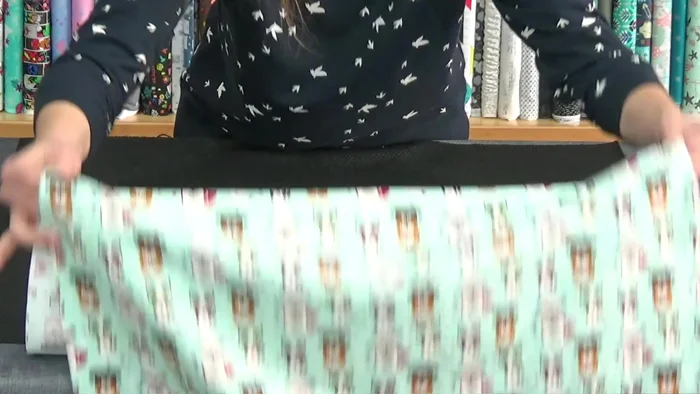 Unir la tela y la suela: Coloca el derecho de la tela antideslizante con el derecho de la tela principal. Asegura que la suela sea más grande que la tela. Sujeta con alfileres alrededor, doblando la cremallera.