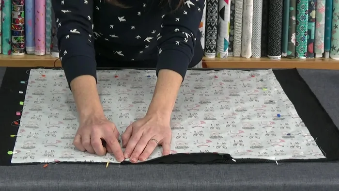 Coser el contorno: Realiza una costura alrededor del perímetro a unos 0.75 cm del borde. Recuerda solapar las costuras de la cremallera para mayor sujeción.