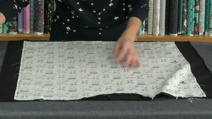 Recortar y dar la vuelta: Quita los alfileres, recorta el sobrante de tela, y corta las esquinas. Da la vuelta al cojín por la cremallera.