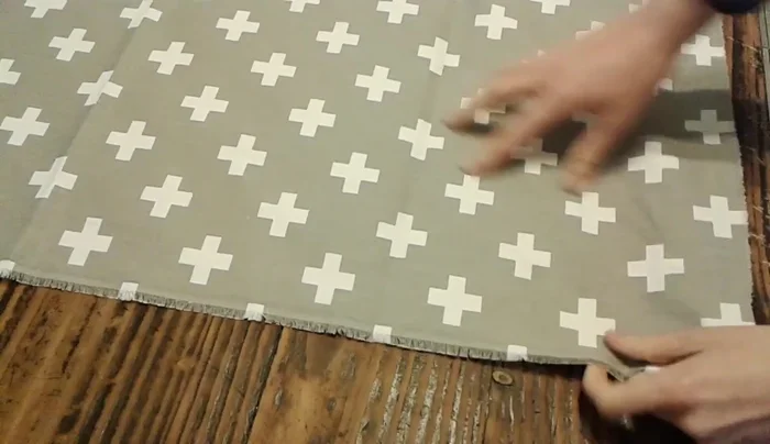 Cortar la tela estampada: Colocar una de las piezas de toalla sobre la tela estampada y cortar por la diagonal, formando otro triángulo.