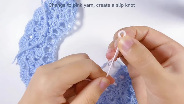 Cambiar a hilo rosa y tejer una cadeneta. Unir al trabajo azul en la primera cadena y tejer un punto bajo en cada espacio (48 puntos bajos en total, múltiplo de 6).